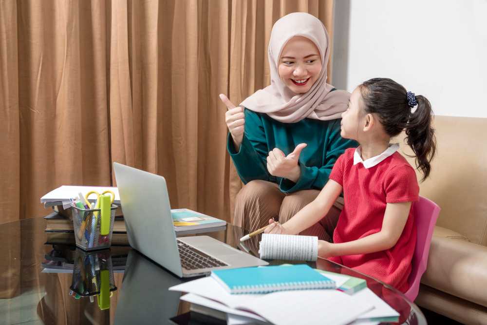 A young female Muslim teacher teaching a small girl
